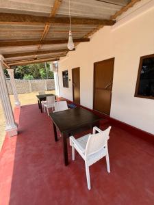 a patio with tables and chairs on a red floor at Diving Club Beach Resort in Trincomalee +12 photos