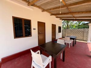 a room with a table and chairs on a patio at Diving Club Beach Resort in Trincomalee