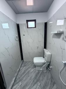 a bathroom with a white toilet and a window at Diving Club Beach Resort in Trincomalee