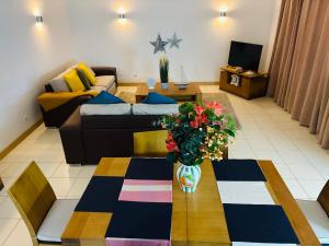 a living room with a couch and a table with flowers at Vozinha Residence in Prainha