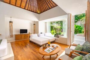 a living room with a white couch and a table at Candi Beach Resort & Spa in Candidasa