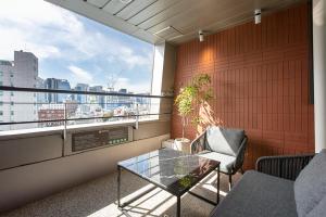 a balcony with a table and a chair and a window at Hotel PJ Myeongdong in Seoul