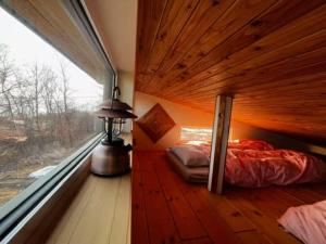 a bedroom with a bed in a room with a window at Sauna Paistaa in Sobetsu