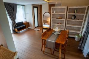 a living room with a wooden table and a mirror at Tuju Villa Hamparan Syariah in Ciledug