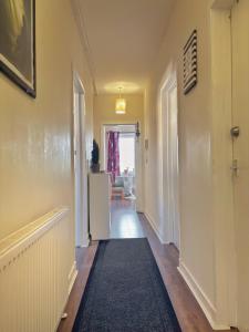 a hallway with a refrigerator and a hallway with a room at Spacious room close to tram in Edinburgh