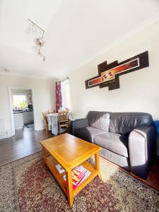 a living room with a couch and a table at Spacious room close to tram in Edinburgh