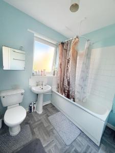 a bathroom with a toilet and a tub and a sink at Spacious room close to tram in Edinburgh