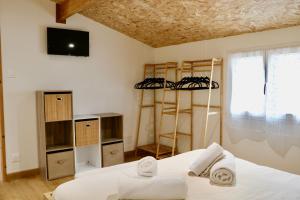 a room with a bed and a tv and shelves at Chalet l'Escale du Cèdre in Rivières