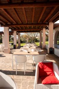 a row of tables and chairs under a pavilion at Moniga Resort in Moniga