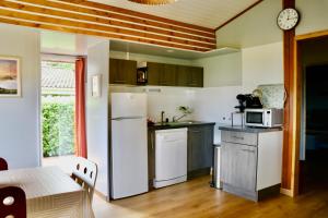 a kitchen with a white refrigerator and a microwave at Chalet l'Escale du Cèdre in Rivières