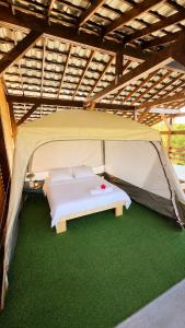 a white bed in a tent with green carpet at Marina Park in Vama Veche