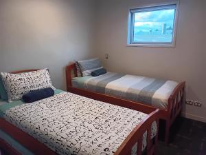 a room with two beds and a window at 111 3rd Avenue Tauranga in Tauranga