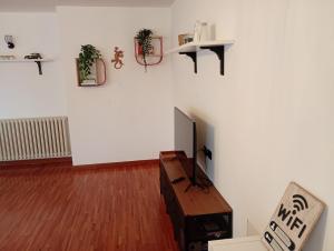 a living room with a tv on a white wall at Bright apartment between Como and Milan in Lurago Marinone