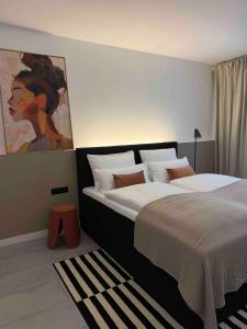 a bedroom with two beds and a painting on the wall at MY STAY - Smart Hotel in Mönchengladbach