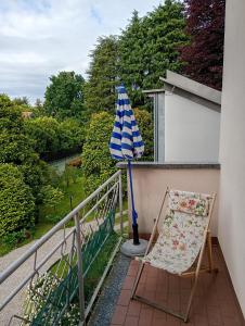 a chair and an umbrella on a balcony at Bright apartment between Como and Milan in Lurago Marinone
