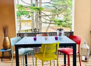 a table with colorful chairs around it in a room at L'Écrin du Petit Prince SoCozy in Toulouse