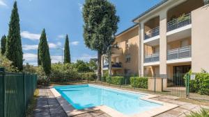 an apartment with a swimming pool in front of a building at L'Écrin du Petit Prince SoCozy in Toulouse