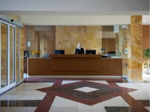 Eine Frau sitzt an einem Schreibtisch in einer Lobby in der Unterkunft Health & Wellness Center Energetikas in Šventoji + 31 Fotos