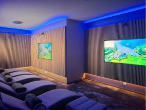 ein Zimmer mit einer Stuhlreihe und einem Flachbildfernseher in der Unterkunft Health & Wellness Center Energetikas in Šventoji