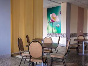 ein Zimmer mit Tischen und Stühlen und einer Blume an der Wand in der Unterkunft Health & Wellness Center Energetikas in Šventoji