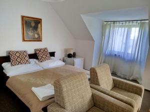 a bedroom with a bed and a couch and a chair at Penzión Malý Dvor in Štúrovo +11 photos