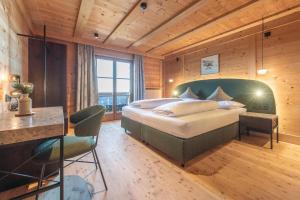 a bedroom with a bed and a desk in a room at HOFERALPL hike-in-mountainhouse in Bagni di Lavina Bianca
