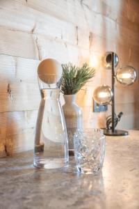 a table with two vases and a glass at HOFERALPL hike-in-mountainhouse in Bagni di Lavina Bianca +33 photos