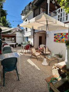 a patio with chairs and tables and an umbrella at Zimmer Camere in Sirolo