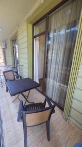 a patio with a table and chairs and a glass door at Sunny Hotel in Kobuleti