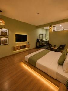 a bedroom with a large bed and a flat screen tv at Heritage Resort's Jageshwar in Jageshwar +4 photos