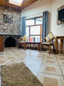a living room with a table and chairs and a fireplace at frozen valley in Mukteshwar