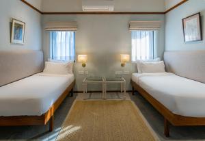 a room with two beds and a table in it at Amrit Bhawan in Haridwār +36 photos