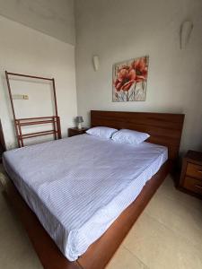 a bedroom with a large bed with white sheets at Nymph Villa in Pannipitiya +10 photos