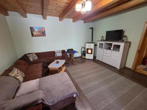a living room with a couch and a flat screen tv at Cabana Anita in Sovata