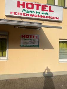 a sign for a hotel on the side of a building at Pension Passion Julie in Berlin