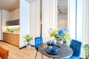 a dining room with a table and blue chairs at ApartHotel S8 - Apartamenty Wrocław in Wrocław