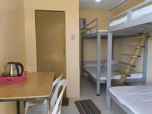 a dining room with a table and a bunk bed at Elyu Seaside beach house in San Juan