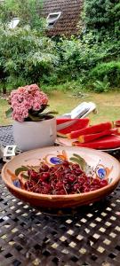 a plate of red food on a table with a vase of flowers at Statek Vojtěšín in Vojtěšín