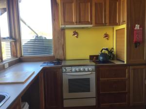 a kitchen with a stove and a sink and a window at Dolphin Beach House in Swansea