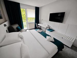 a hotel room with two white beds and a television at Horský hotel Montana in Špindlerův Mlýn +51 photos