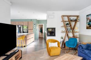 a living room with a tv and a kitchen at Breizh'ome in Saint-Cast-le-Guildo