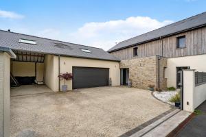 a house with a garage and a driveway at Breizh'ome in Saint-Cast-le-Guildo