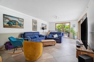 a living room with two blue couches and a tv at Breizh'ome in Saint-Cast-le-Guildo