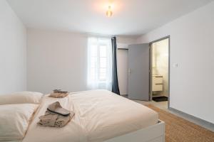 a white bedroom with a bed with a hat and towels at Secret Garden in Vias