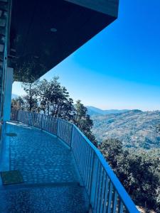 a blue balcony with a view of a valley at frozen valley in Mukteshwar