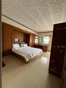 a bedroom with a bed and a coffered ceiling at Aarroh villa in Coonoor
