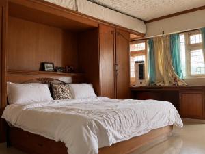 a bedroom with a large bed with a wooden headboard at Aarroh villa in Coonoor