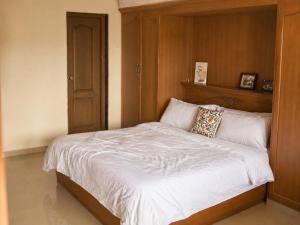 a bed with a wooden headboard in a bedroom at Aarroh villa in Coonoor