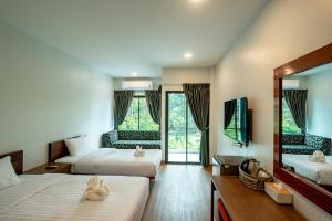 a hotel room with two beds and a mirror at Sinai Rimtalay Hotel in Ban Nong Sanom +113 photos