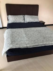 a bedroom with a large bed with a wooden headboard at The Ceo Suites in Bayan Lepas